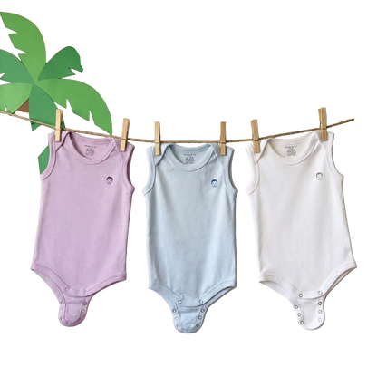 Three sleeveless baby bodysuits in lavender, light blue, and white hang on a wooden clothesline against a cream wall decorated with paper palm leaves, blue birds, and colorful flowers. A 'Chic & Co Baby' logo is visible at the top.