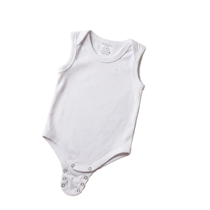 White baby onesie on a beige surface with colorful star and cloud decorations and a teddy bear.